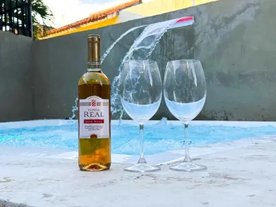 a bottle of wine and two wine glasses on a table at Haven Villa Retreat Jacuzzi Oasis for 16 in Mata los Indios