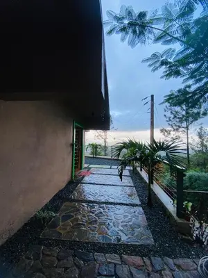 a stone walkway next to a building with a fence at Villa el privilegio in Jarabacoa