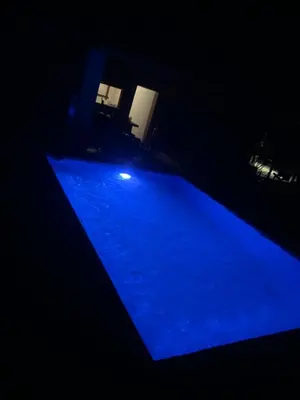 a blue swimming pool in a dark room at Villa el privilegio in Jarabacoa
