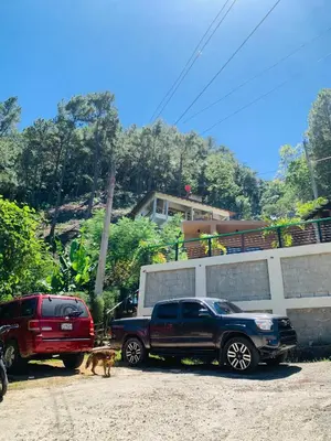 a truck and a dog parked next to a house at Villa el privilegio in Jarabacoa