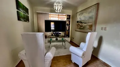 a living room with two white chairs and a glass table at Villa Robilu