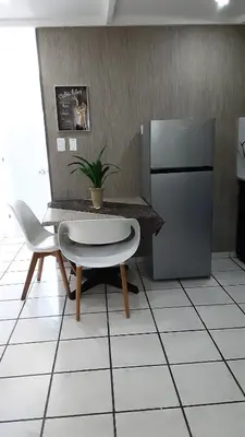 a kitchen with a table and a chair and a refrigerator at Tortuga Cabarete Resindencial in Sosua