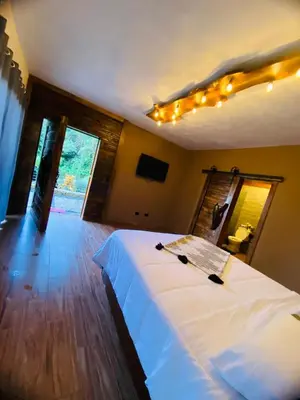 a bedroom with a large white bed with lights on the ceiling at Villa el privilegio in Jarabacoa
