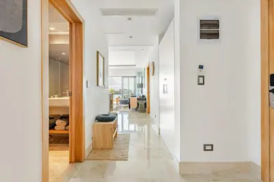 a hallway of a home with white walls and a white hallway at Modern Oceanview Retreat with Balcony and Walk to Bay in Santa Bárbara de Samaná