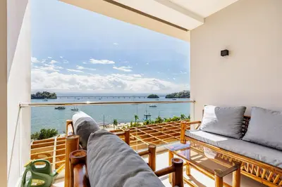 a balcony with a couch and a view of the ocean at Modern Oceanview Retreat with Balcony and Walk to Bay in Santa Bárbara de Samaná