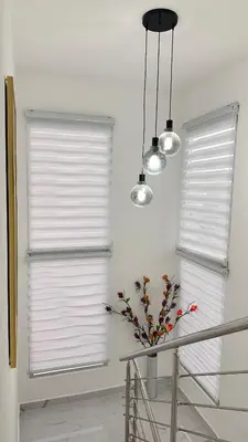 a room with two windows with white blinds and a table with flowers at VILLA 127 La Intensa Del Caribe in Pueblo Bavaro