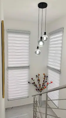 two windows with white blinds and a vase with flowers at VILLA 127 La Intensa Del Caribe in Pueblo Bavaro
