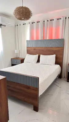 a bedroom with a large bed with a wooden headboard at VILLA 127 La Intensa Del Caribe in Pueblo Bavaro