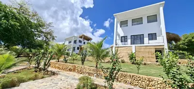 a house with a retaining wall next to a building at SunSeaBeach Villa Iguana - 3 SZ - Strandnähe in Las Galeras