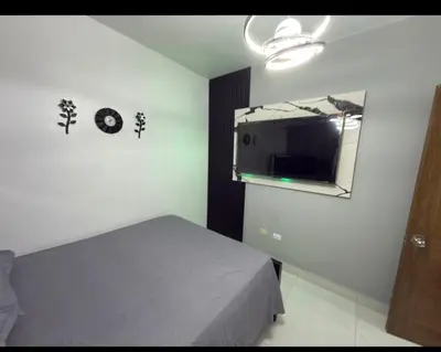 a bedroom with a mirror and a bed in a room at EG suits rentals in San Felipe de Puerto Plata