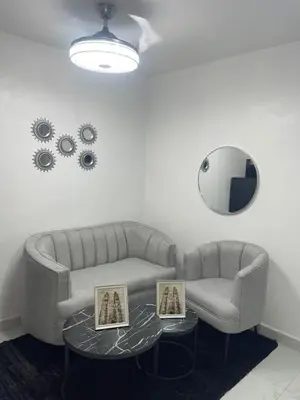 a living room with two couches and a table and a mirror at EG suits rentals in San Felipe de Puerto Plata