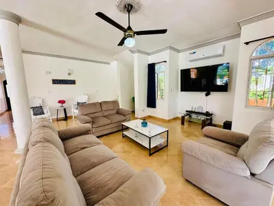 a living room with a couch and a ceiling fan at Villa Tropical Cabarete in Sosua