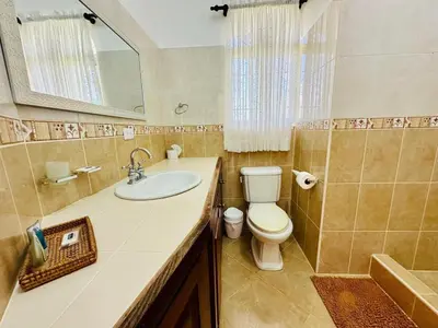 a bathroom with a sink and a toilet and a mirror at Villa Tropical Cabarete in Sosua