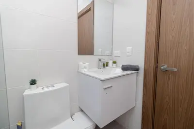 a white bathroom with a sink and a mirror at Elegant Coastal Escape Spacious 2BR Bayahibe in San Rafael del Yuma