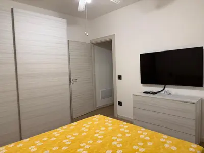 a bedroom with a flat screen tv and a yellow rug at Paradiso Italia Miches in Miches