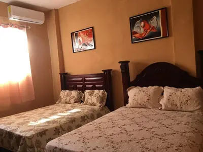 a bedroom with two beds and a window at Hotel Pensión la Hermosa Barahona in Santa Cruz de Barahona