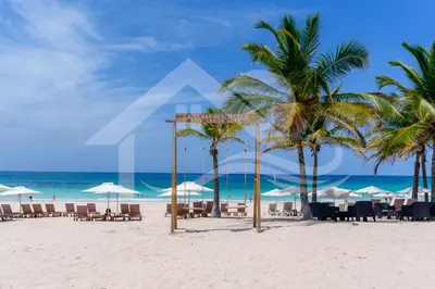 a beach with chairs and umbrellas and the ocean at Vista Velero – 1BR Coastal Escape @ Cana Rock Star in Punta Cana