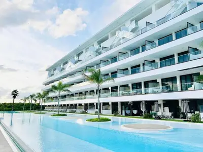 a large building with a swimming pool in front of it at Vista Velero – 1BR Coastal Escape @ Cana Rock Star in Punta Cana