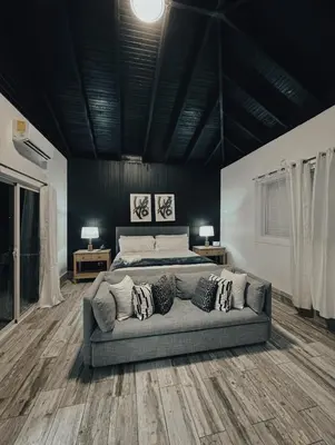 a bedroom with a bed and a couch with pillows at Villa Ana in Santiago de los Caballeros
