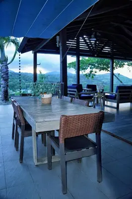 a wooden table and chairs on a patio at Villa Ana in Santiago de los Caballeros