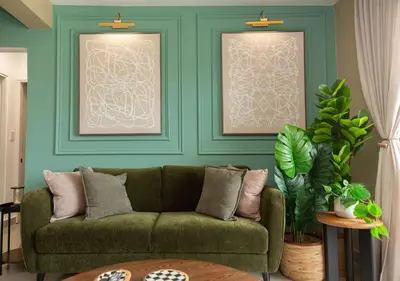 a living room with a green couch and blue walls at The Jade Lodge 2BR Apartment- Enjoy the nature in Puerto Plata