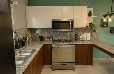a kitchen with a stove and a sink at The Jade Lodge 2BR Apartment- Enjoy the nature in Puerto Plata