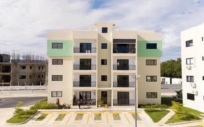 an apartment building in front of a parking lot at The Jade Lodge 2BR Apartment- Enjoy the nature in Puerto Plata