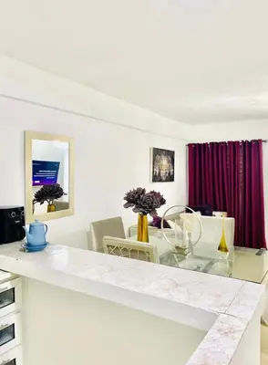 a kitchen with a glass counter top and a table at Apartment with Everything AC Wifi and Solar panel in Bonao