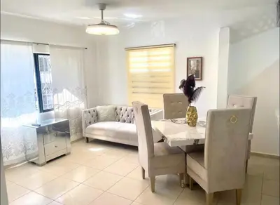 a living room with a table and a couch at Centrally located Comfortable Apartment in Bonao
