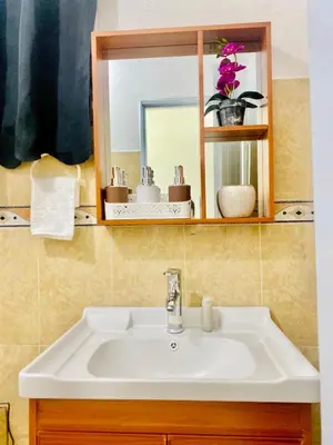a white sink in a bathroom with a mirror at Centrally located Comfortable Apartment in Bonao