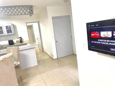 a kitchen with a television and a kitchen with a counter at Centrally located Comfortable Apartment in Bonao