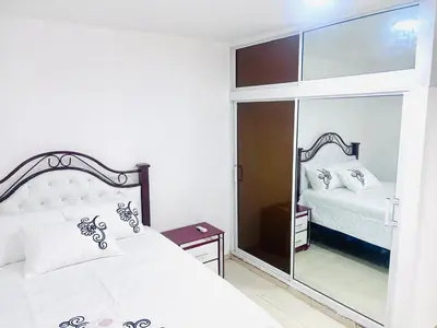a bedroom with a bed and a large mirror at Centrally located Comfortable Apartment in Bonao