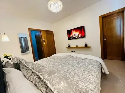 a bedroom with a bed and a tv on the wall at Tranquilo y acogedor in Santiago de los Caballeros
