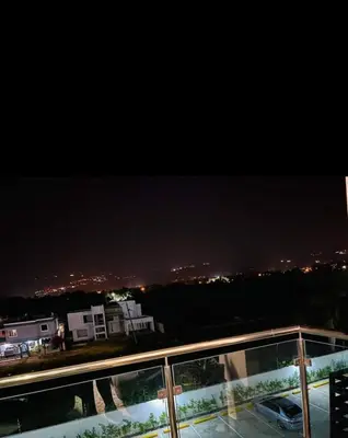 a view of a city at night from a balcony at Tranquilo y acogedor in Santiago de los Caballeros