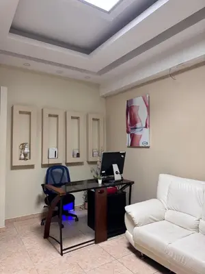 a living room with a couch and a desk with a computer at Habitaciónes suite 10 min del Monumento & Agora Mall in Santiago de los Caballeros