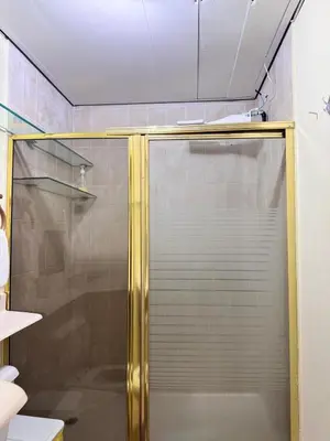 a shower with a glass door in a bathroom at Habitaciónes suite 10 min del Monumento & Agora Mall in Santiago de los Caballeros