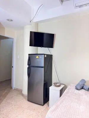 a small refrigerator in a room with a bed at Habitaciónes suite 10 min del Monumento & Agora Mall in Santiago de los Caballeros