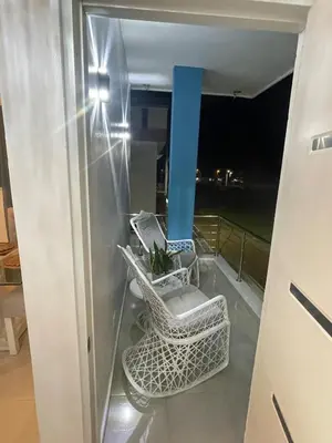 a balcony with two chairs and a blue pole at Byk in Nagua