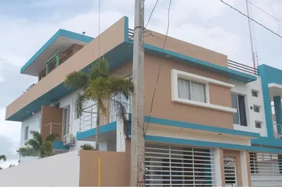 a building with a palm tree in front of it at Byk in Nagua