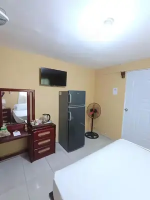 a kitchen with a refrigerator and a table and a mirror at Ideal para Dormir in Los Patos