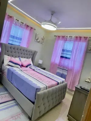 a bedroom with a large bed with pink curtains at Skyline Stays in La Viva