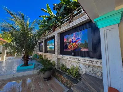 a building with a tv on the side of it at Villa Palmera Barahona, Dream Getaway in Santa Cruz de Barahona