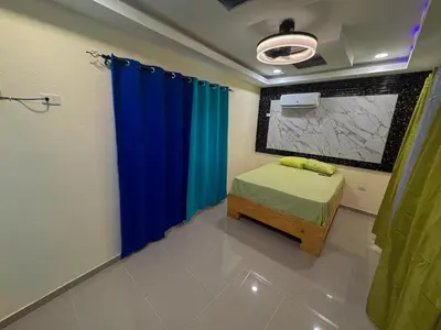 a bedroom with a bed and a blue curtain at Villa Palmera Barahona, Dream Getaway in Santa Cruz de Barahona