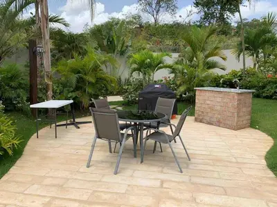 a patio with a table and chairs and trees at The perfect destination to relax in Santiago de los Caballeros