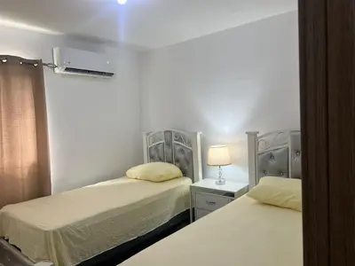 a bedroom with two beds and a lamp on a table at The perfect destination to relax in Santiago de los Caballeros
