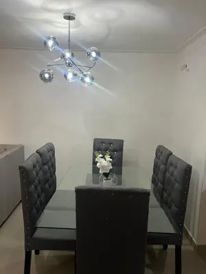 a dining room table with two chairs and a chandelier at The perfect destination to relax in Santiago de los Caballeros