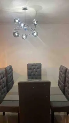 a dining table with two chairs and a chandelier at The perfect destination to relax in Santiago de los Caballeros