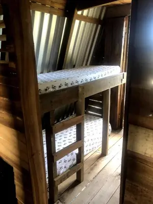 a wooden bunk bed in a room with wooden floors at Mi casita de Campo en Bayaguana in Bayaguana