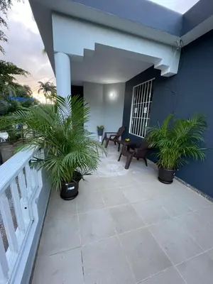 a patio with two chairs and palm trees on a house at Apartamento en el Corazón de Las Terrenas in Las Terrenas
