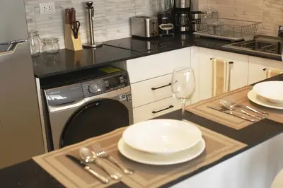 a kitchen with a table with plates and a dishwasher at 1BRM Infinity Homes Punta Cana in Punta Cana